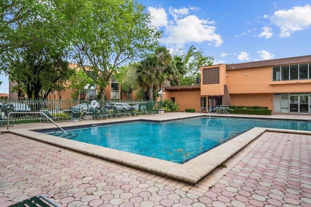 community pool featuring a patio area and fence