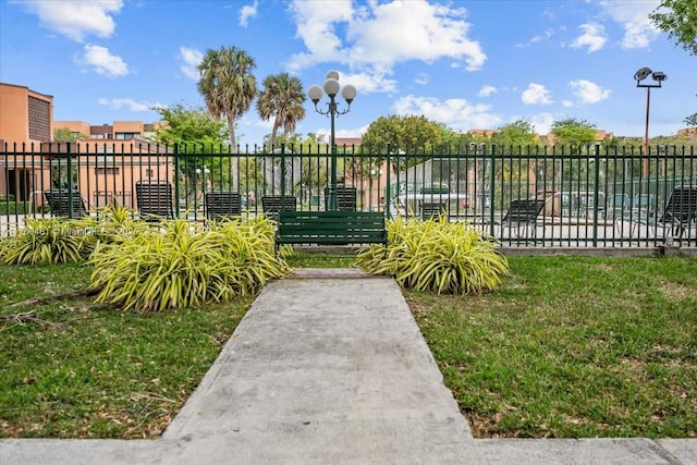 view of gate with a lawn and fence