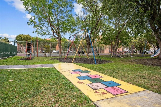 view of home's community with playground community, a yard, and fence