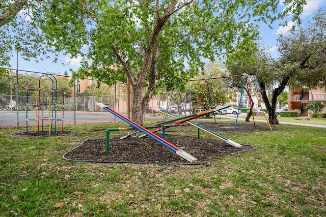 view of home's community featuring playground community, a yard, and fence