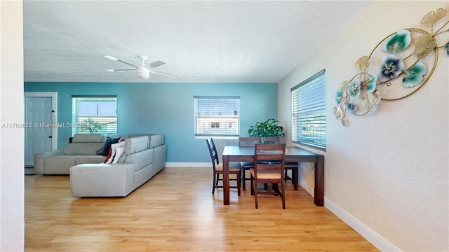 dining room featuring a healthy amount of sunlight, baseboards, light wood-style floors, and ceiling fan