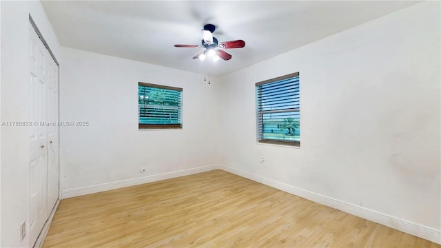 unfurnished bedroom with ceiling fan, baseboards, a closet, and light wood-type flooring