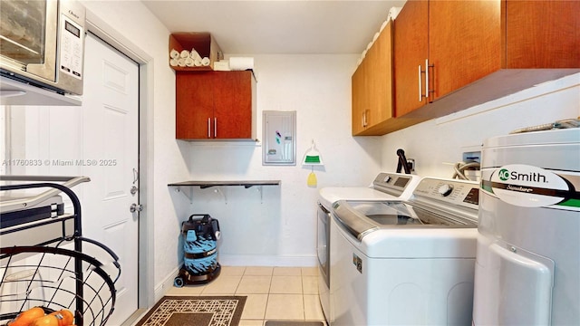 clothes washing area with independent washer and dryer, electric panel, cabinet space, light tile patterned flooring, and baseboards