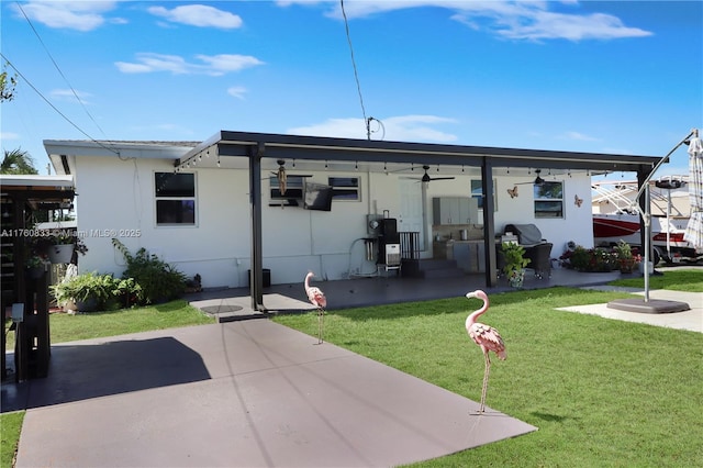 view of front of property with a patio, a ceiling fan, and a front lawn