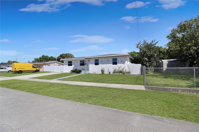 view of front facade with stucco siding, concrete driveway, a front lawn, and fence