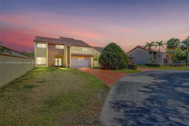 view of front of house with a front yard, a tiled roof, and driveway