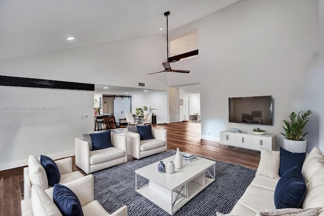 living area with visible vents, baseboards, ceiling fan, wood finished floors, and high vaulted ceiling