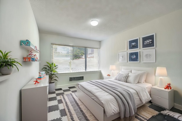 bedroom featuring tile patterned floors, a textured ceiling, and baseboards