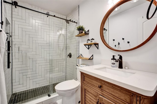 bathroom featuring a stall shower, toilet, and vanity