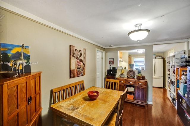 dining room featuring dark wood-type flooring and crown molding