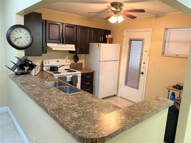 kitchen with crown molding, under cabinet range hood, light tile patterned floors, white appliances, and a sink