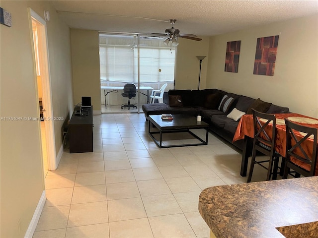 living room featuring baseboards, a textured ceiling, ceiling fan, and light tile patterned flooring