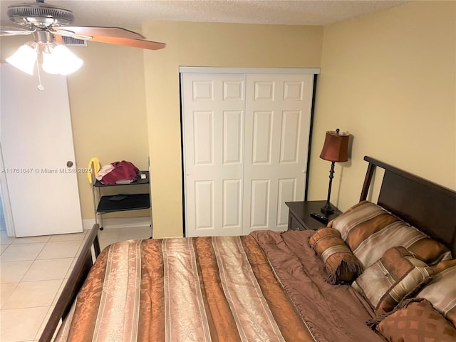 tiled bedroom with a closet, a textured ceiling, and ceiling fan