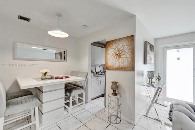 dining area with light tile patterned floors, visible vents, and baseboards