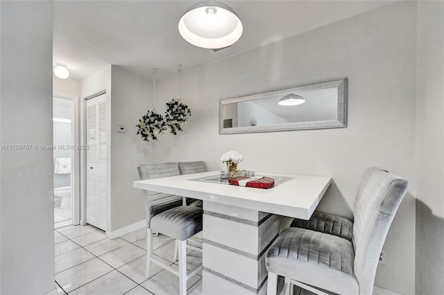 dining area featuring light tile patterned floors and baseboards