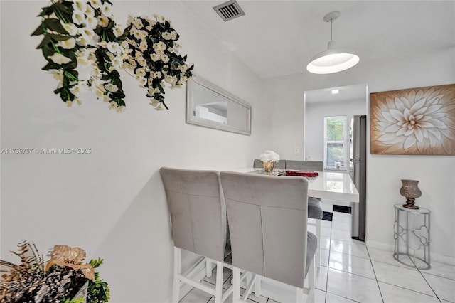 dining area featuring light tile patterned floors and visible vents