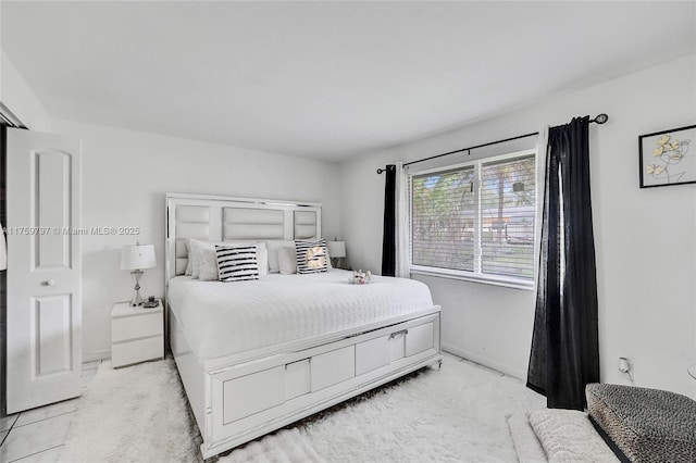 bedroom with light colored carpet and baseboards