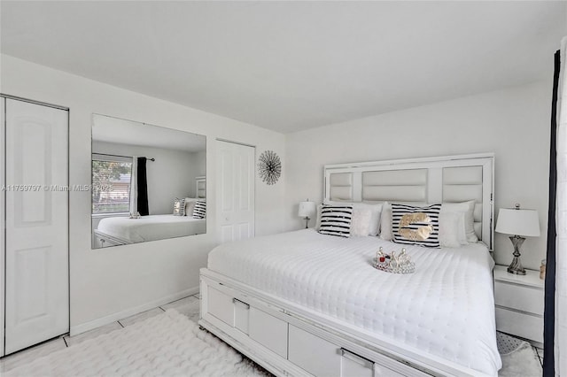 bedroom with baseboards and multiple closets