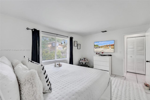 bedroom with light tile patterned floors, visible vents, and baseboards