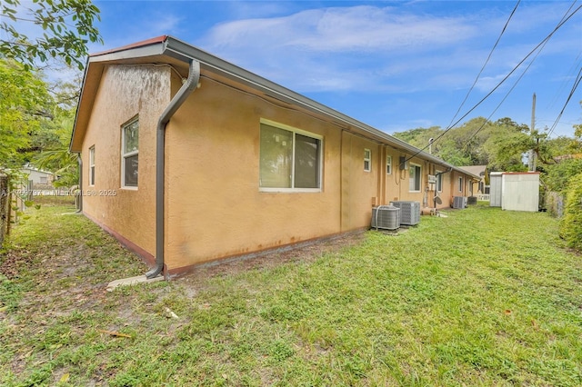 exterior space with an outdoor structure, central air condition unit, a lawn, and stucco siding