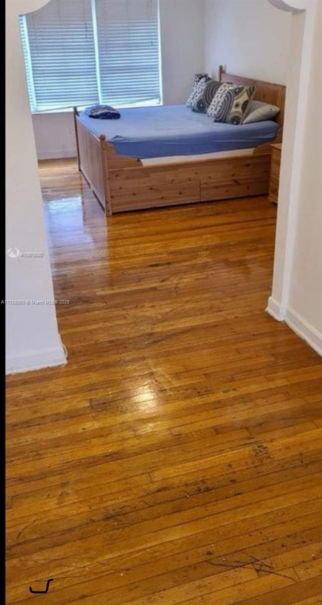 unfurnished bedroom featuring baseboards and wood finished floors