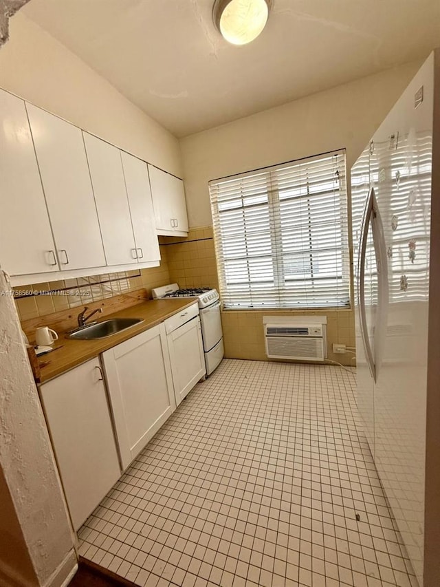 830 Euclid Ave Unit 8, Miami Beach, FL 33139 - kitchen featuring a sink, white gas range, white cabinetry, light tile patterned floors, and a wall mounted AC