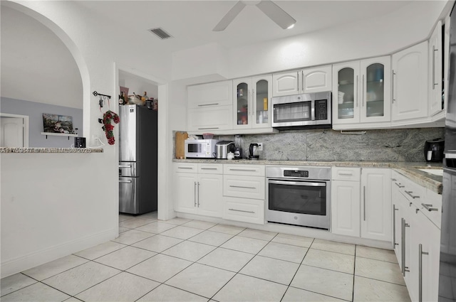 kitchen featuring visible vents, backsplash, ceiling fan, light tile patterned floors, and appliances with stainless steel finishes