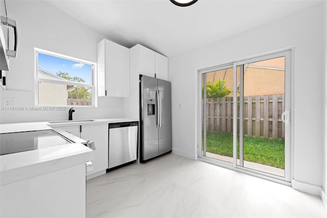 834 Cumberland Ter, Davie, FL 33325 - kitchen with stainless steel appliances, light marble finish flooring, white cabinets, a sink, and light countertops
