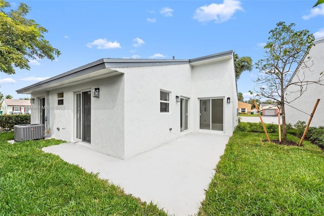834 Cumberland Ter, Davie, FL 33325 - back of house featuring central AC unit, stucco siding, a lawn, and a patio area