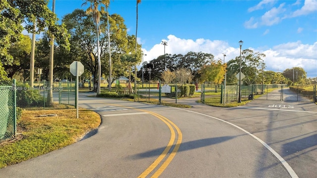 834 Cumberland Ter, Davie, FL 33325 - view of asphalt street featuring traffic signs, a gate, and street lights