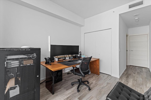 office area featuring wood finished floors, visible vents, and baseboards