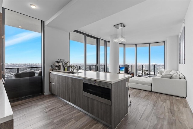 kitchen featuring light countertops, floor to ceiling windows, modern cabinets, and light wood-type flooring