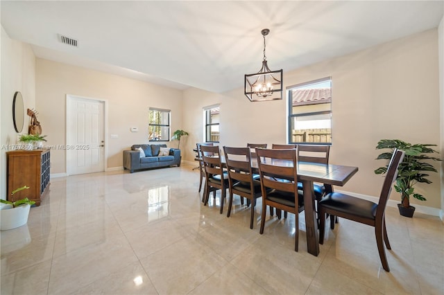 dining space featuring a notable chandelier, baseboards, and visible vents