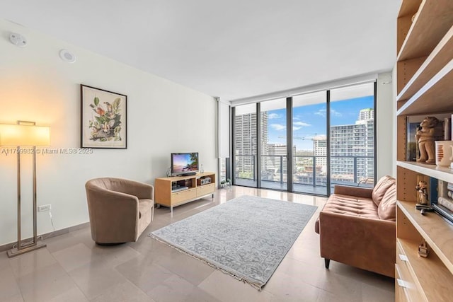 living area featuring a wall of windows and baseboards