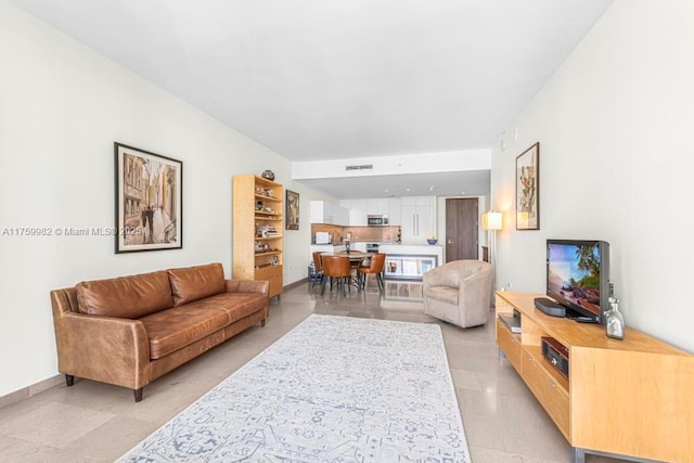 living area with baseboards and visible vents