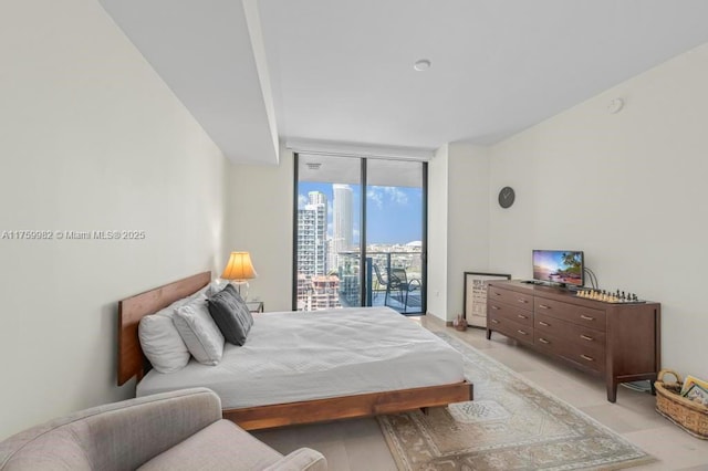 bedroom featuring expansive windows and access to exterior