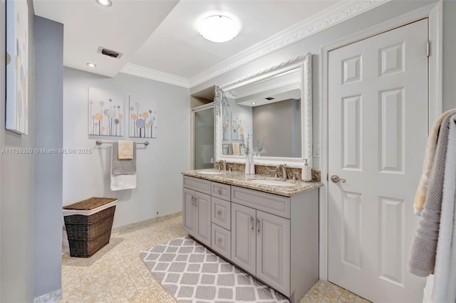 bathroom featuring visible vents, ornamental molding, a sink, a shower with door, and double vanity