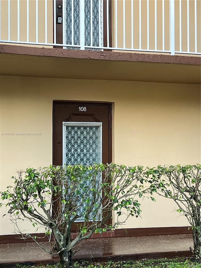 doorway to property featuring stucco siding