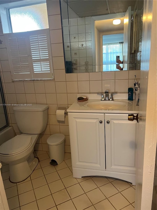 bathroom featuring a wealth of natural light, toilet, walk in shower, and vanity