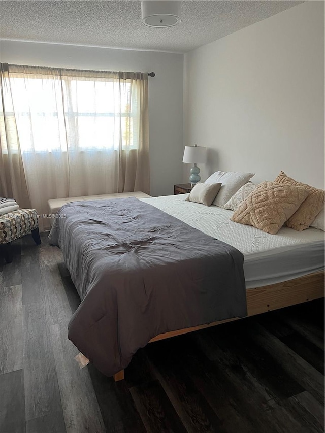 bedroom featuring a textured ceiling and wood finished floors