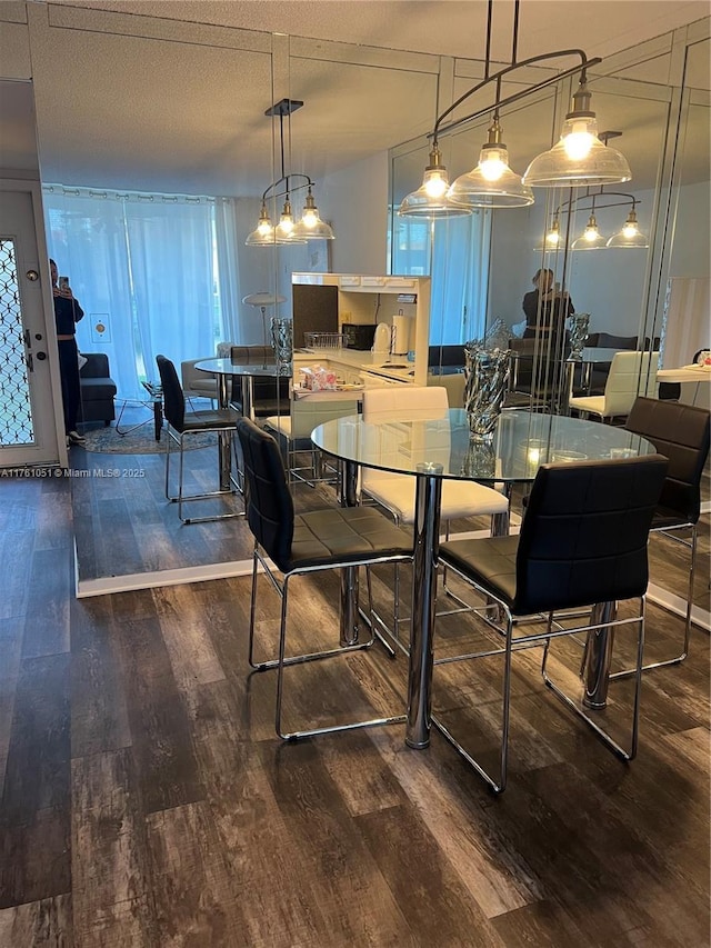 dining space featuring a textured ceiling and wood finished floors