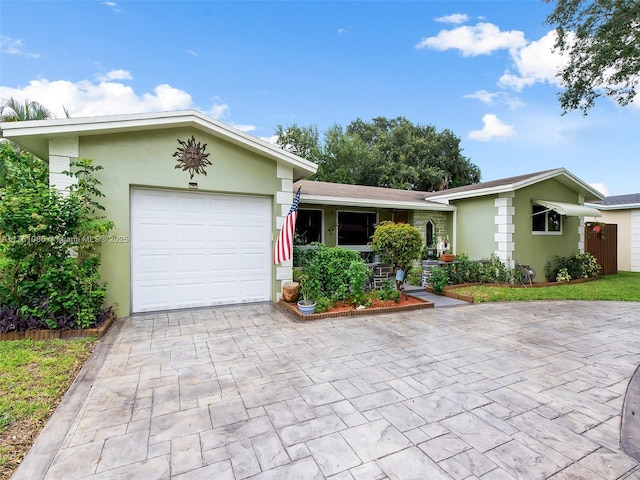 single story home with stucco siding, an attached garage, and decorative driveway