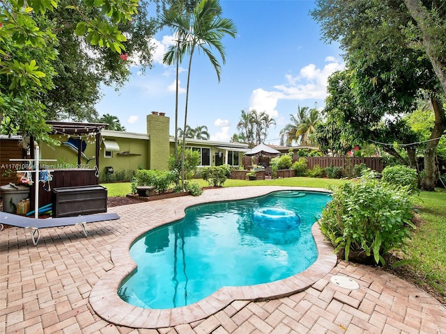 view of pool featuring a patio area, a hot tub, a fenced in pool, and fence