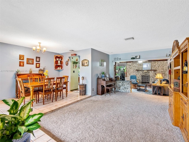 living room with visible vents, light tile patterned flooring, a textured ceiling, a notable chandelier, and light colored carpet