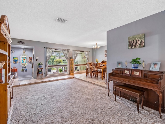 interior space with tile patterned flooring, a notable chandelier, a textured ceiling, and visible vents