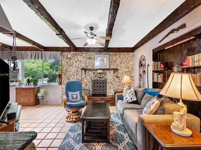 living area featuring beamed ceiling, a textured ceiling, a fireplace, and tile patterned flooring