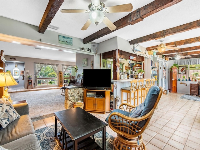 living area featuring light tile patterned floors, beam ceiling, a textured ceiling, and ceiling fan