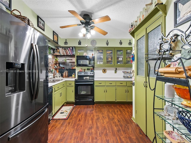 kitchen featuring a textured ceiling, black appliances, green cabinets, and light countertops