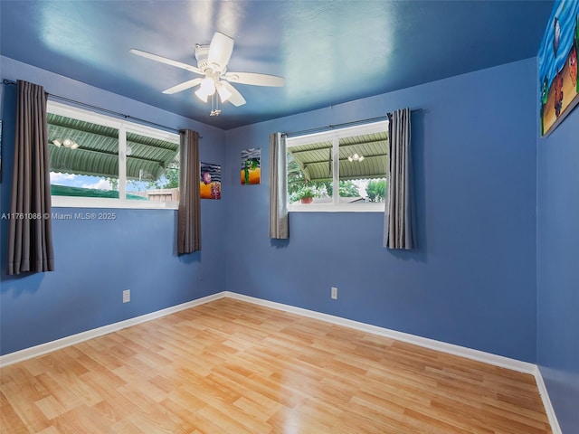 unfurnished room with baseboards, wood finished floors, and a ceiling fan