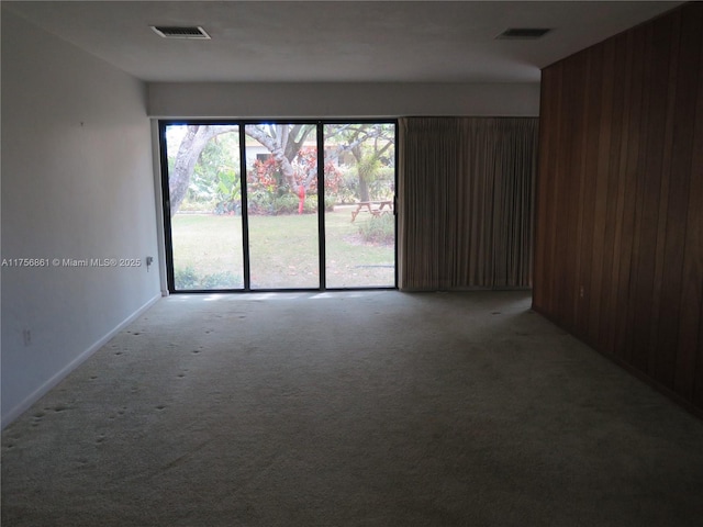 spare room featuring light carpet and visible vents